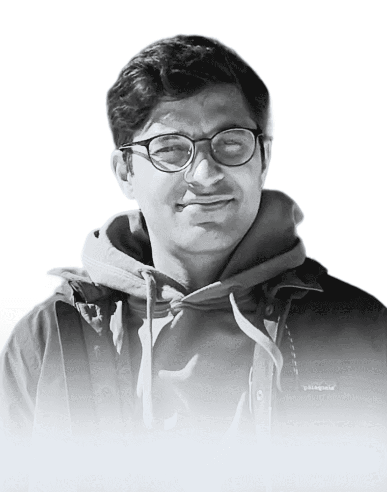 Black-and-white portrait of Karan Bharadwaj in glasses and a hooded jacket.