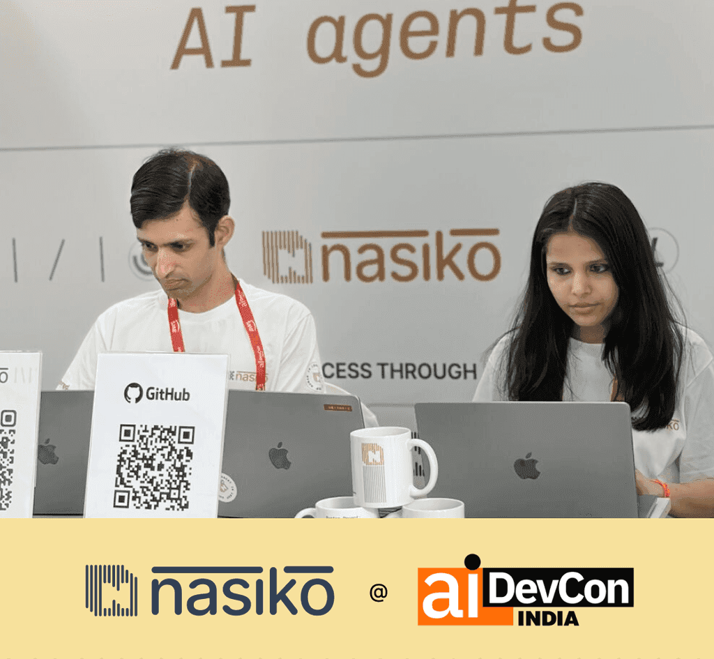 The Nasiko booth at AI DevCon India 2026 in Bengaluru, mid-conversation with attendees.