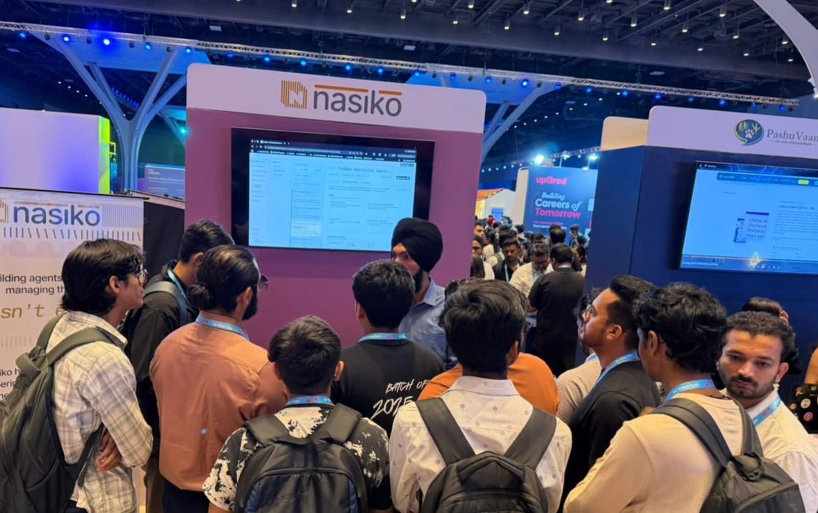 Attendees gathered around the Nasiko booth at Mumbai Tech Week, watching a live product demo on the booth's screen.